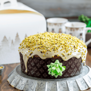 Panettone basso nel suo stampo, su una tavola imbandita